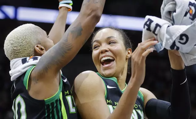 Minnesota Lynx guard Courtney Williams (10) and forward Napheesa Collier (24) celebrate the win against the Phoenix Mercury after Game 2 of a WNBA basketball first-round playoff game Wednesday, Sept. 25, 2024, in Minneapolis. (AP Photo/Bruce Kluckhohn)