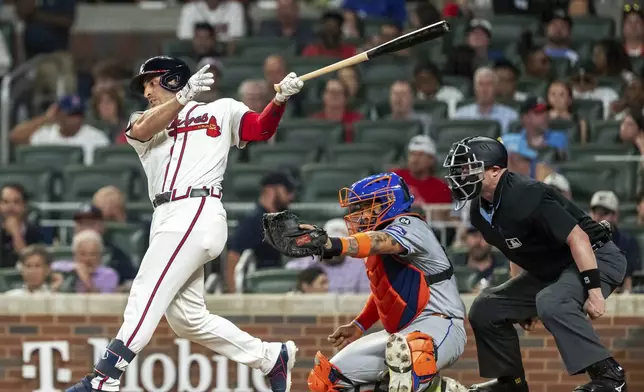 New York Mets catcher Francisco Alvarez, center, catches the ball as Atlanta Braves' Ramón Laureano, left, swings at a pitch in the third inning of a baseball game, Tuesday, Sept. 24, 2024, in Atlanta. (AP Photo/Jason Allen)