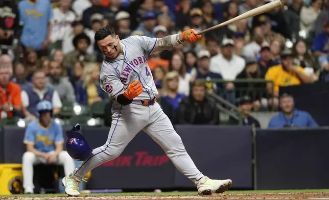 New York Mets' Francisco Alvarez loses his helmet after swinging during the fourth inning of a baseball game against the Milwaukee Brewers, Friday, Sept. 27, 2024, in Milwaukee. (AP Photo/Aaron Gash)