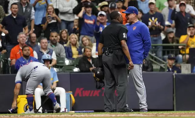 New York Mets manager Carlos Mendoza, right, yells to umpire Ramon De Jesus, second from right, after being ejected during the fourth inning of a baseball game against the Milwaukee Brewers, Friday, Sept. 27, 2024, in Milwaukee. (AP Photo/Aaron Gash)