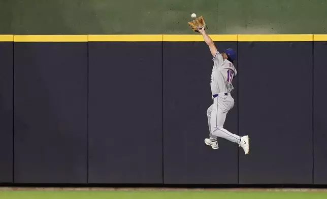 New York Mets' Tyrone Taylor makes a leaping catch of a ball during the sixth inning of a baseball game against the Milwaukee Brewers, Friday, Sept. 27, 2024, in Milwaukee. (AP Photo/Aaron Gash)