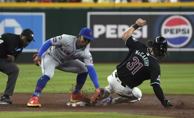 Arizona Diamondbacks' Jake McCarthy (31) slides into second base safely under the tag by New York Mets shortstop Francisco Lindor in the third inning of a baseball game, Wednesday, Aug. 28, 2024, in Phoenix. (AP Photo/Rick Scuteri)