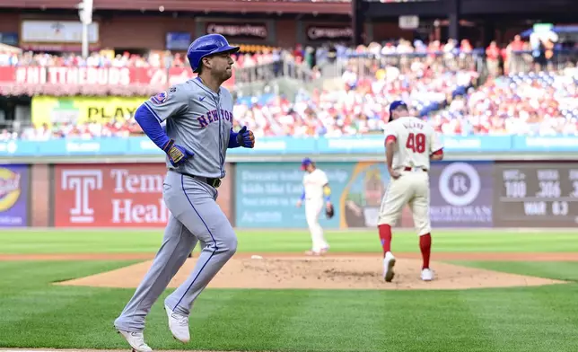 New York Mets' Jose Iglesias, left, scores after Philadelphia Phillies' Kolby Allard, right, walked Mets' Starling Marte with the bases loaded during the first inning of a baseball game, Saturday, Sept. 14, 2024, in Philadelphia. (AP Photo/Derik Hamilton)