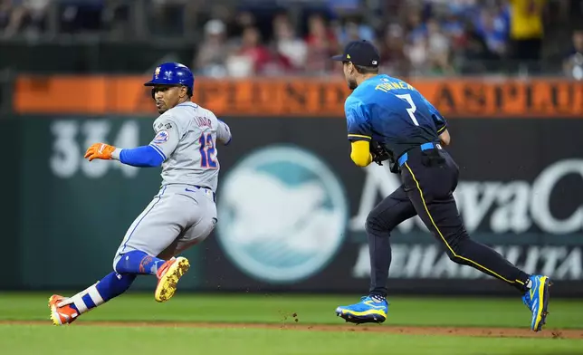 New York Mets' Francisco Lindor, left, is tagged out by Philadelphia Phillies' Trea Turner (7) after trying to advance to third base during the sixth inning of a baseball game, Friday, Sept. 13, 2024, in Philadelphia. (AP Photo/Derik Hamilton)