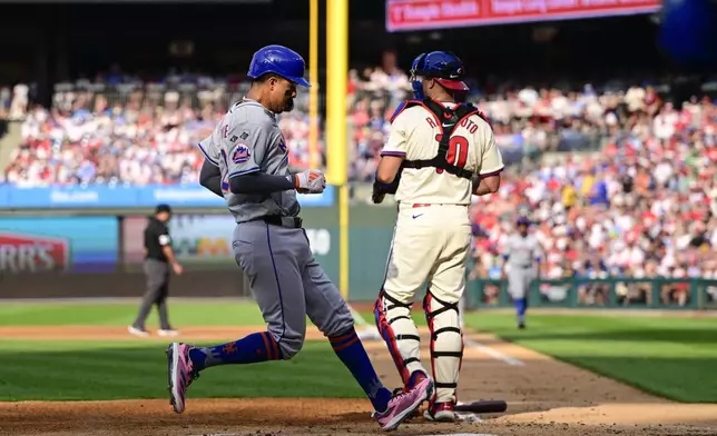 New York Mets' Mark Vientos, left, scores past Philadelphia Phillies' J.T. Realmuto, right, during the third inning of a baseball game, Saturday, Sept. 14, 2024, in Philadelphia. (AP Photo/Derik Hamilton)