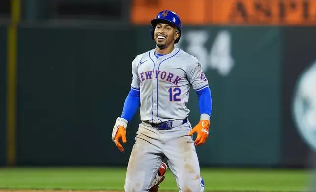 New York Mets' Francisco Lindor smiles after he was tagged out by Philadelphia Phillies' Trea Turner while trying to advance to third base during the sixth inning of a baseball game, Friday, Sept. 13, 2024, in Philadelphia. (AP Photo/Derik Hamilton)