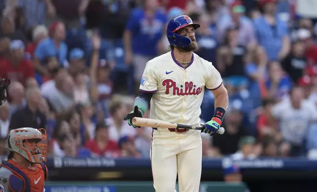 Philadelphia Phillies' Bryce Harper, right, watches his two-run home run off New York Mets' Luis Severino during the sixth inning of a baseball game, Saturday, Sept. 14, 2024, in Philadelphia. (AP Photo/Derik Hamilton)