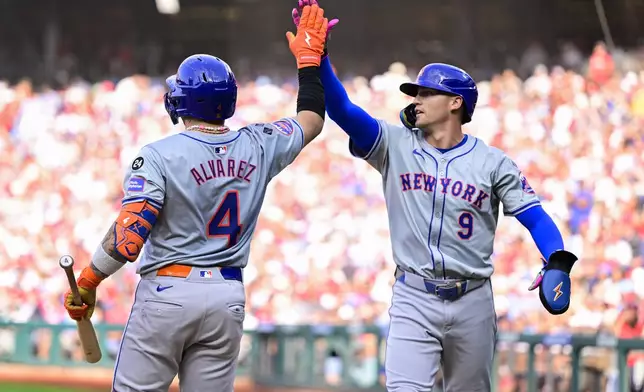 New York Mets' Brandon Nimmo, right, high-fives Francisco Alvarez (4) after scoring during the third inning of a baseball game, Saturday, Sept. 14, 2024, in Philadelphia. (AP Photo/Derik Hamilton)