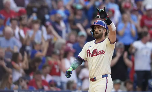 Philadelphia Phillies' Bryce Harper reacts after hitting a two-run home run off New York Mets' Luis Severino during the sixth inning of a baseball game, Saturday, Sept. 14, 2024, in Philadelphia. (AP Photo/Derik Hamilton)