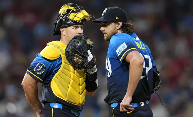 Philadelphia Phillies' Aaron Nola, right, talks to J.T. Realmuto during the fifth inning of a baseball game against the New York Mets, Friday, Sept. 13, 2024, in Philadelphia. (AP Photo/Derik Hamilton)