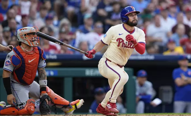 Philadelphia Phillies' Cal Stevenson, right, watches his two-run double off New York Mets' Reed Garrett during the seventh inning of a baseball game, Saturday, Sept. 14, 2024, in Philadelphia. (AP Photo/Derik Hamilton)