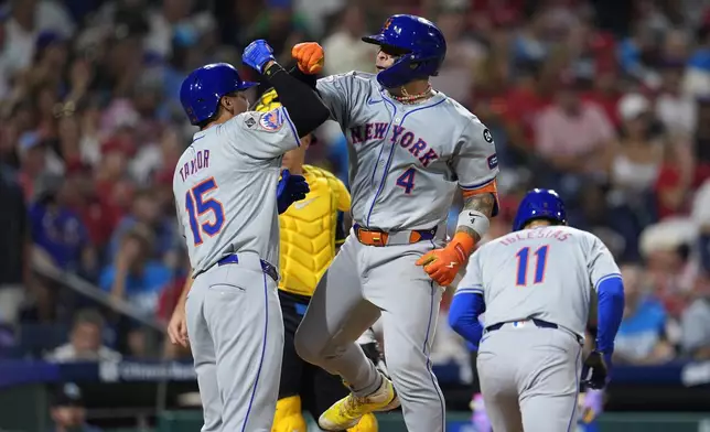 New York Mets' Francisco Alvarez (4) celebrates his three run home run off Philadelphia Phillies' Aaron Nola with Mets' Tyrone Taylor (15) during the fifth inning of a baseball game, Friday, Sept. 13, 2024, in Philadelphia. (AP Photo/Derik Hamilton)