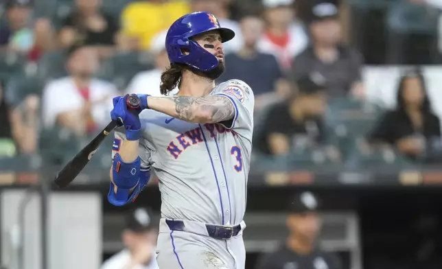 New York Mets' Jesse Winker watches his RBI sacrifice fly during the third inning of a baseball game against the Chicago White Sox on Saturday, Aug. 31, 2024, in Chicago. (AP Photo/Charles Rex Arbogast)