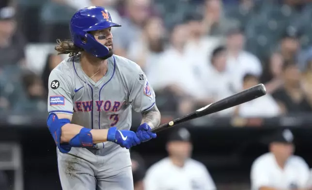 New York Mets' Jesse Winker watches his RBI sacrifice fly during the third inning of a baseball game against the Chicago White Sox on Saturday, Aug. 31, 2024, in Chicago. (AP Photo/Charles Rex Arbogast)