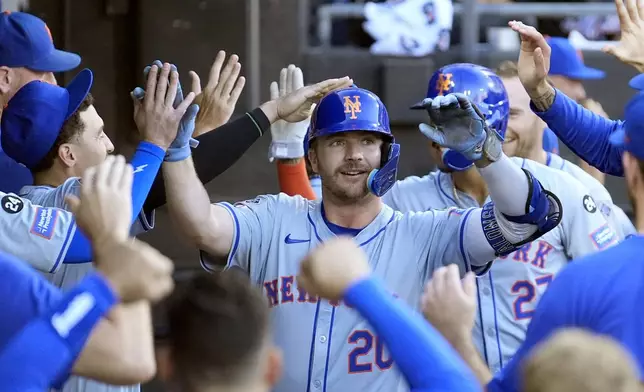 The New York Mets' Pete Alonso is greeted in the dugout after his two-run home run off Chicago White Sox starting pitcher Davis Martin during the first inning of a baseball game Saturday, Aug. 31, 2024, in Chicago. (AP Photo/Charles Rex Arbogast)