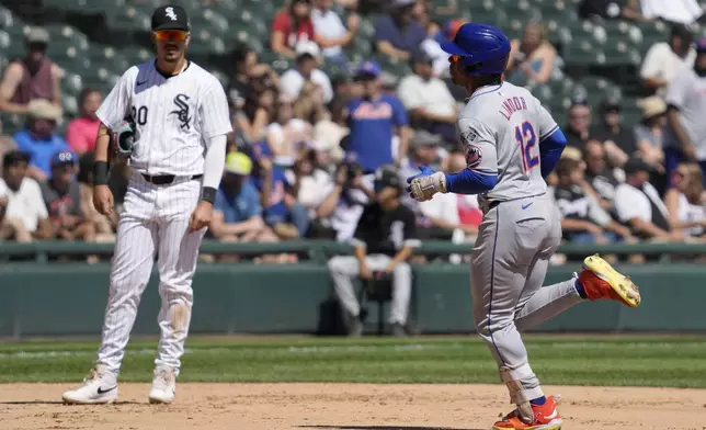 New York Mets' Francisco Lindor, right, rounds the bases after hitting a solo home run as Chicago White Sox third baseman Miguel Vargas, left, looks on during the fourth inning of a baseball game in Chicago, Sunday, Sept. 1, 2024. (AP Photo/Nam Y. Huh)