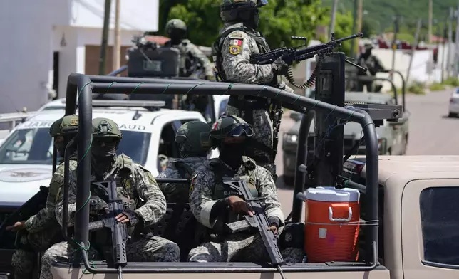 National Guards and Army forces patrol the streets during an operation in a neighborhood of Culiacan, Sinaloa state, Mexico, Thursday, Sept. 19, 2024. (AP Photo/Eduardo Verdugo)