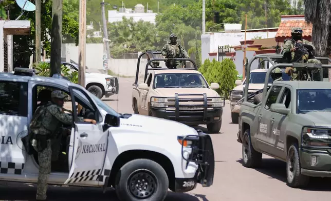 National Guard forces and Army soldiers patrol during an operation in a neighborhood of Culiacan, Sinaloa state, Mexico, Thursday, Sept. 19, 2024. (AP Photo/Eduardo Verdugo)