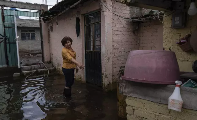 Claudia Alvarado points to damage from sewage-infused floodwaters at her home in Valle de Chalco, State of Mexico, Thursday, Aug. 29, 2024. (AP Photo/Felix Marquez)