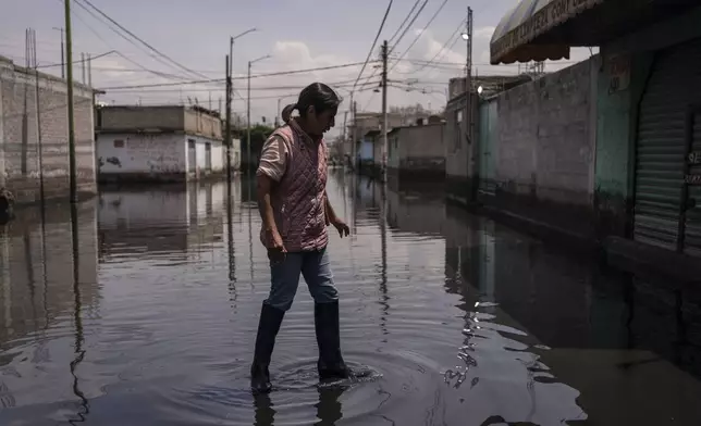 Juana Salazar Segundo walks through sewage-infused floodwaters in Valle de Chalco, State of Mexico, Thursday, Aug. 29, 2024. (AP Photo/Felix Marquez)