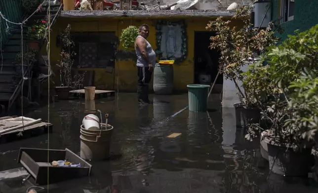 Oscar Martínez Hinojosa supervises a hose pumping sewage-infused floodwaters out of his home in Valle de Chalco, State of Mexico, Thursday, Aug. 29, 2024. (AP Photo/Felix Marquez)