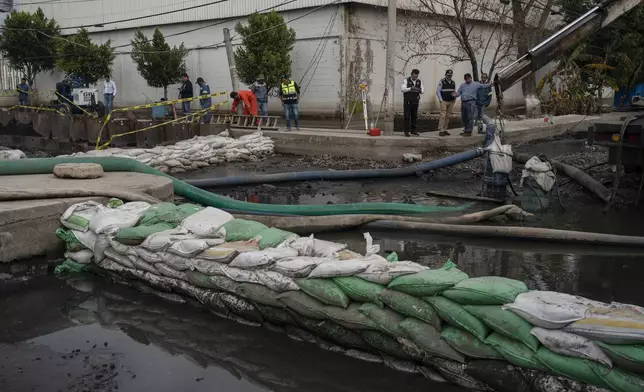 Workers pump out sewage-infused floodwaters in Valle de Chalco, State of Mexico, Monday, Sept. 9, 2024. (AP Photo/Felix Marquez)