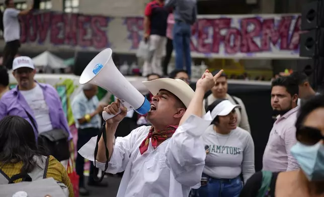 A man shouts uses a bullhorn to shout slogans during a rally in favor of the government's proposed judicial reform outside the Supreme Court building in Mexico City, Thursday, Sept. 5, 2024. (AP Photo/Eduardo Verdugo)