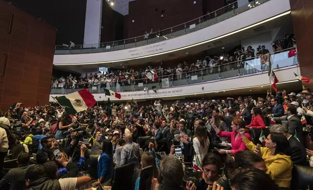 Protesters stand alongside opposition Senators after interrupting a debate over the government's proposed judicial reform, which would make judges stand for election, in Mexico City, Tuesday, Sept. 10, 2024. (AP Photo/Felix Marquez)