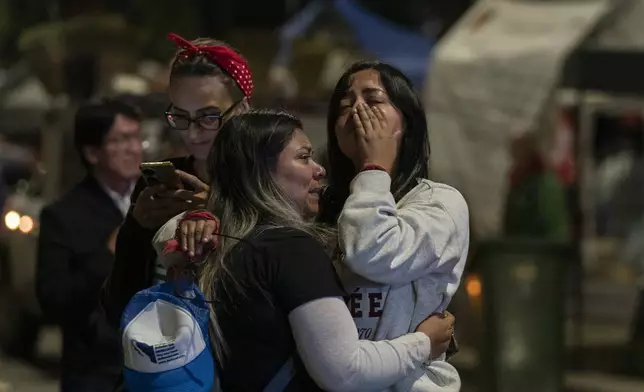 Two women cry after watching senators' vote on a large screen during a protest against government's proposed judicial reform, which would make judges stand for election, outside the Senate in Mexico City, Tuesday, Sept. 10, 2024. (AP Photo/Felix Marquez)