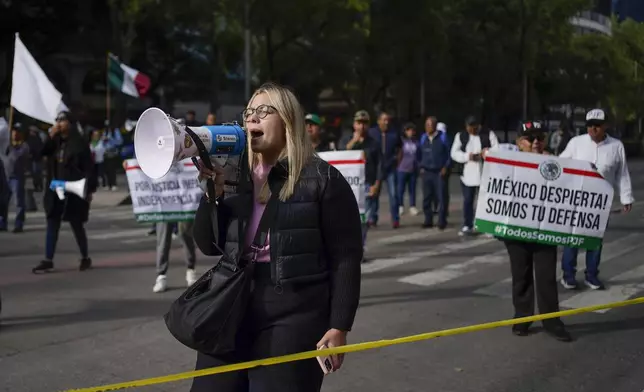 A demonstrator yells into a megaphone to protest against the judicial reform bill outside the Senate in Mexico City, Thursday, Sept. 5, 2024, the day after Congress passed legislation that would require all judges to stand for election. (AP Photo/Felix Marquez)