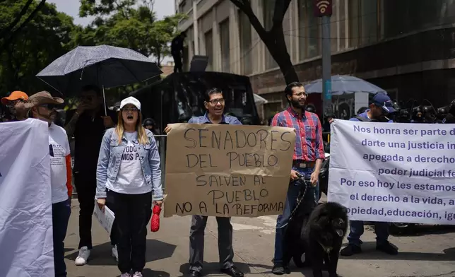 People protest the government's proposed judicial reform, which would require judges to get elected to office, in Mexico City, Wednesday, Sept. 4, 2024. The sign in the middle asks senators to save the people by rejecting the reform. (AP Photo/Felix Marquez)