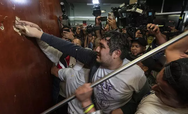 Protesters break into a Senate session in which lawmakers were debating the government's proposed judicial reform, which would make judges stand for election, in Mexico City, Tuesday, Sept. 10, 2024. (AP Photo/Felix Marquez)