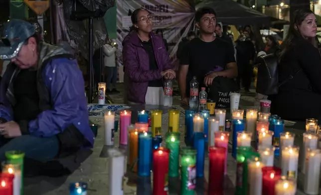 A group of people watch the senators vote on a screen during a protest against the government's proposed judicial reform, which would make judges stand for election, outside the Senate in Mexico City, Tuesday, Sept. 10, 2024. (AP Photo/Felix Marquez)