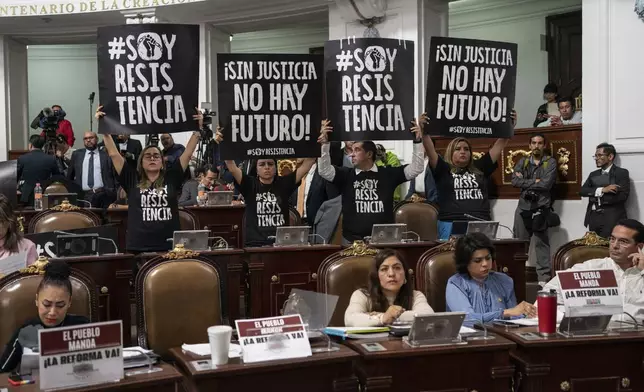 Legislators protest judicial reform in the Mexico City Congress, Thursday, Sept. 12, 2024. The signs read in Spanish "I am resistance, " and "Without justice there's no future." (AP Photo/Felix Marquez)