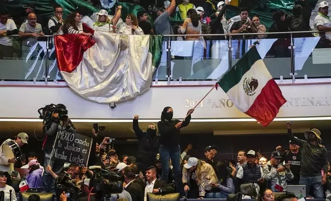 Protesters interrupt a Senate session in which lawmakers were debating the government's proposed judicial reform, which would make judges stand for election, in Mexico City, Tuesday, Sept. 10, 2024. (AP Photo/Felix Marquez)