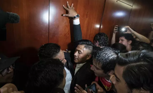 Protesters attempt to bypass a security guard and break into a Senate room, as lawmakers weigh the government's proposed judicial reform, which would make judges stand for election, in Mexico City, Tuesday, Sept. 10, 2024. (AP Photo/Felix Marquez)