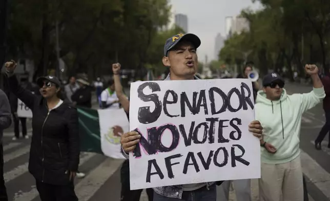 A protester holds a poster that reads in Spanish "Senator, don't vote in favor" against the judicial reform bill, outside the Senate in Mexico City, Thursday, Sept. 5, 2024, the day after Congress passed legislation that would require all judges to stand for election. (AP Photo/Felix Marquez)