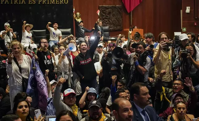 Protesters break into a Senate session in which lawmakers were debating the government's proposed judicial reform, which would make judges stand for election, in Mexico City, Tuesday, Sept. 10, 2024. (AP Photo/Felix Marquez)