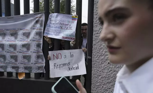 Law students protest against constitutional reform proposals that would make judges stand for election at a sports center where lawmakers are meeting while protesters block Congress in Mexico City, Tuesday, Sept. 3, 2024. The signs read in Spanish: "No to the judicial reform," and "I lost my home. Mexico is my new home. I don't want to lose it. Judicial power cannot be an instrument of political parties, business people, and criminal groups. Students demand impartiality. Independence. (AP Photo/Felix Marquez)