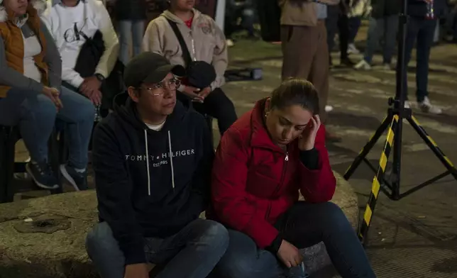 A couple watches the legislators vote on a large screen during a protest the government's proposed judicial reform, which would make judges stand for election, outside the Senate in Mexico City, Tuesday, Sept. 10, 2024. (AP Photo/Felix Marquez)