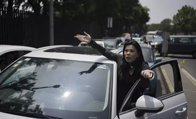 A commuter complains about a roadblock by law students protesting against constitutional reform proposals that would make judges stand for election, outside a sports center where lawmakers are meeting as an alternative due to other demonstrators blocking Congress in Mexico City, Tuesday, Sept. 3, 2024. (AP Photo/Felix Marquez)