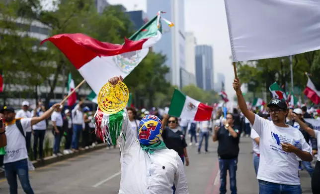 Judicial workers, one wearing a "lucha libre" wrestling mask, protest the government's proposed judicial reform, which would make judges stand for election, outside the Senate in Mexico City, Tuesday, Sept. 10, 2024. (AP Photo/Eduardo Verdugo)