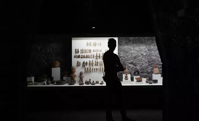 A visitor looks at pre-Hispanic ceramics on display at the Anahuacalli Museum in Mexico City, Tuesday, Aug. 20, 2024. Built by Mexican artist Diego Rivera to preserve and display his lifelong collection of pre-Hispanic art, the museum is celebrating its 60th anniversary. (AP Photo/Eduardo Verdugo)