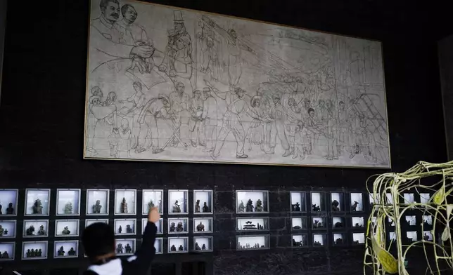 A visitor walks through the interior of the Anahuacalli Museum in Mexico City, Tuesday, Aug. 20, 2024. While its main floor represents the underworld — and feels dimly lit and cold — the second and third levels were inspired by the earthly and celestial worlds, which makes them seem warmer and flooded by light. (AP Photo/Eduardo Verdugo)