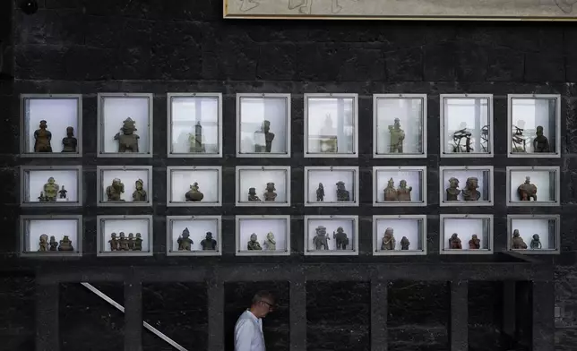 Pre-hispanic ceramics are displayed in glass front niches in the Anahuacalli Museum in Mexico City, Tuesday, Aug. 20, 2024. Built by Mexican artist Diego Rivera to preserve and display his lifelong collection of pre-Hispanic art, the museum is celebrating its 60th anniversary. (AP Photo/Eduardo Verdugo)