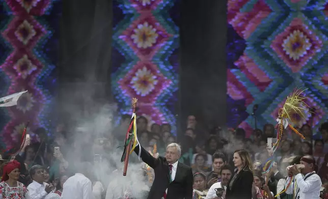 FILE - Newly elected President Andres Manuel Lopez Obrador holds a chieftain's staff during an Indigenous ceremony at the Zocalo in Mexico City, Dec. 1, 2018. (AP Photo/Eduardo Verdugo, File)