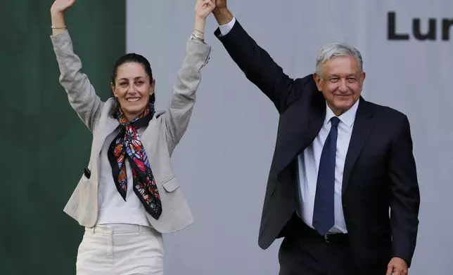 FILE - Mexican President Andres Manuel Lopez Obrador, right, and Mexico City's Mayor Claudia Sheinbaum greet supporters after a rally to celebrate the one-year anniversary of his election in the Zocalo of Mexico City, July 1, 2019. (AP Photo/Fernando Llano, File)