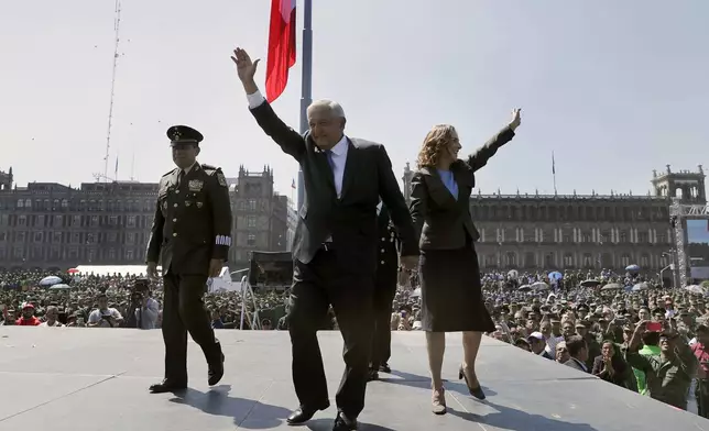 FILE - Mexican President Andres Manuel Lopez Obrador and first lady Beatriz Gutierrez Muller wave during an event marking the Army Day at the Zocalo in Mexico City, Feb. 19, 2020. (AP Photo/Marco Ugarte, File)