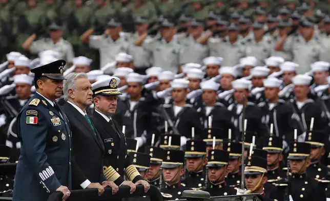 FILE - Mexican President Andres Manuel Lopez Obrador stands between Defense Secretary Luis Crescencio Sandoval, left, and Navy Secretary Vidal Francisco Soberon during the Independence Day military parade at the Zocalo in Mexico City, Sept. 16, 2019. (AP Photo/Marco Ugarte, File)