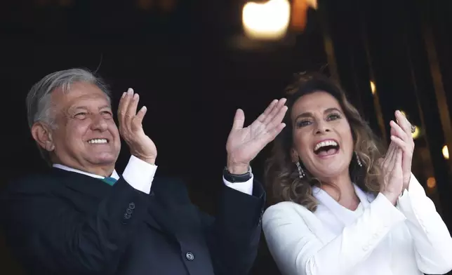 FILE - Mexican President Andres Manuel Lopez Obrador and first lady Beatriz Gutierrez Muller greet the crowd during an Independence Day military parade at the Zocalo in Mexico City, Sept. 16, 2019. (AP Photo/Marco Ugarte, File)